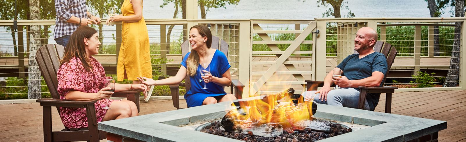 Couples relaxing by firepit in Riverlights park amenity.