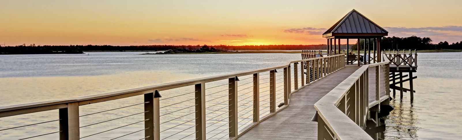 Sunset view over the Cape Fear river along boardwalk trail in Riverlights.