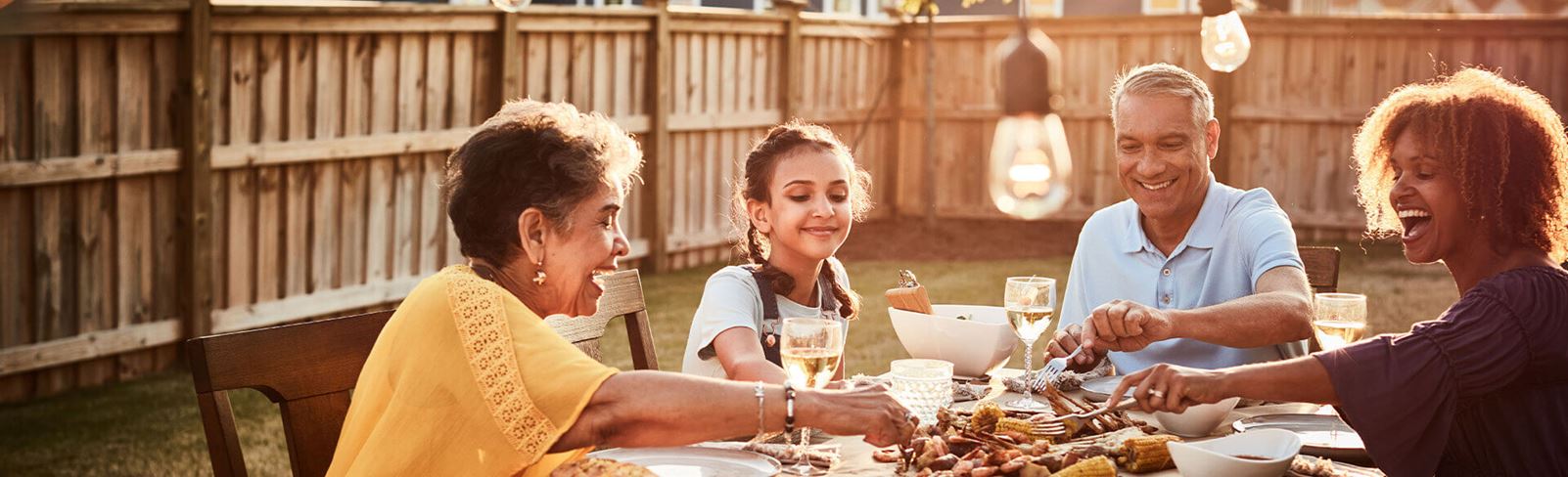 Family enjoying meal in the backyard of their Riverlights home.