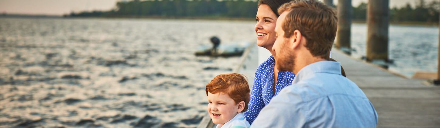 Family sitting on boardwalk along Cape Fear River in Riverlights