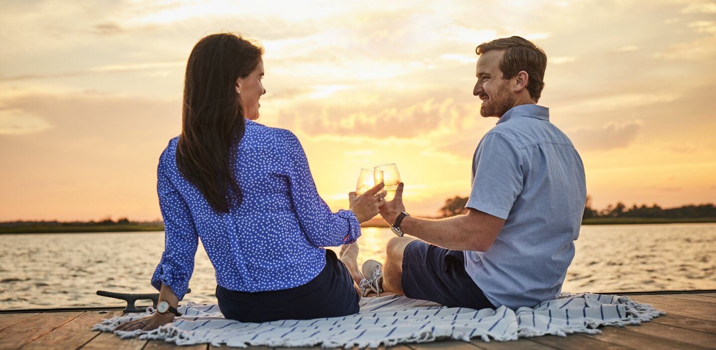 Couple sitting along boardwalk at sunset